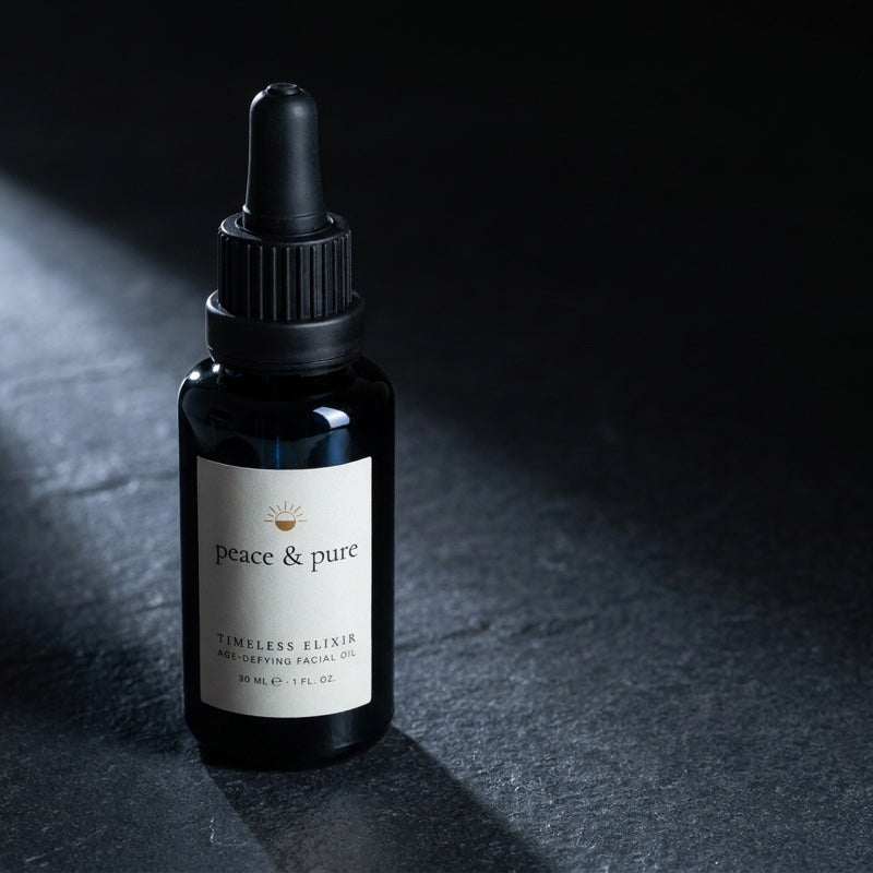 Timeless Elixir in black glass, side-lit on dark slate
